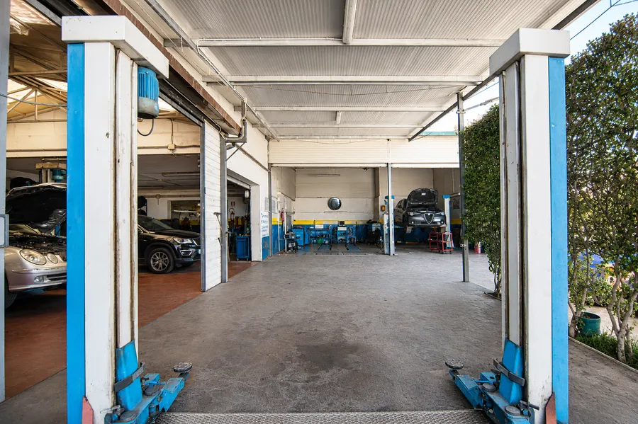 Vista esterna dell'officina Mundo Car Center con box aperti e gomme impilate